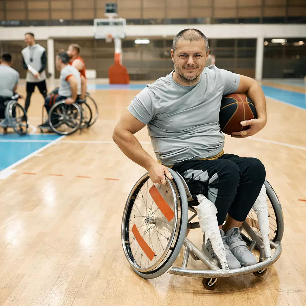 A disabled man in a wheelchair playing basketball