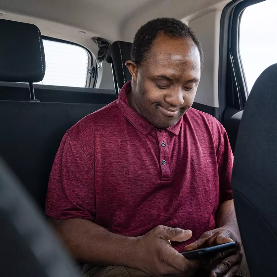 A down syndrome man in the back seat of a car